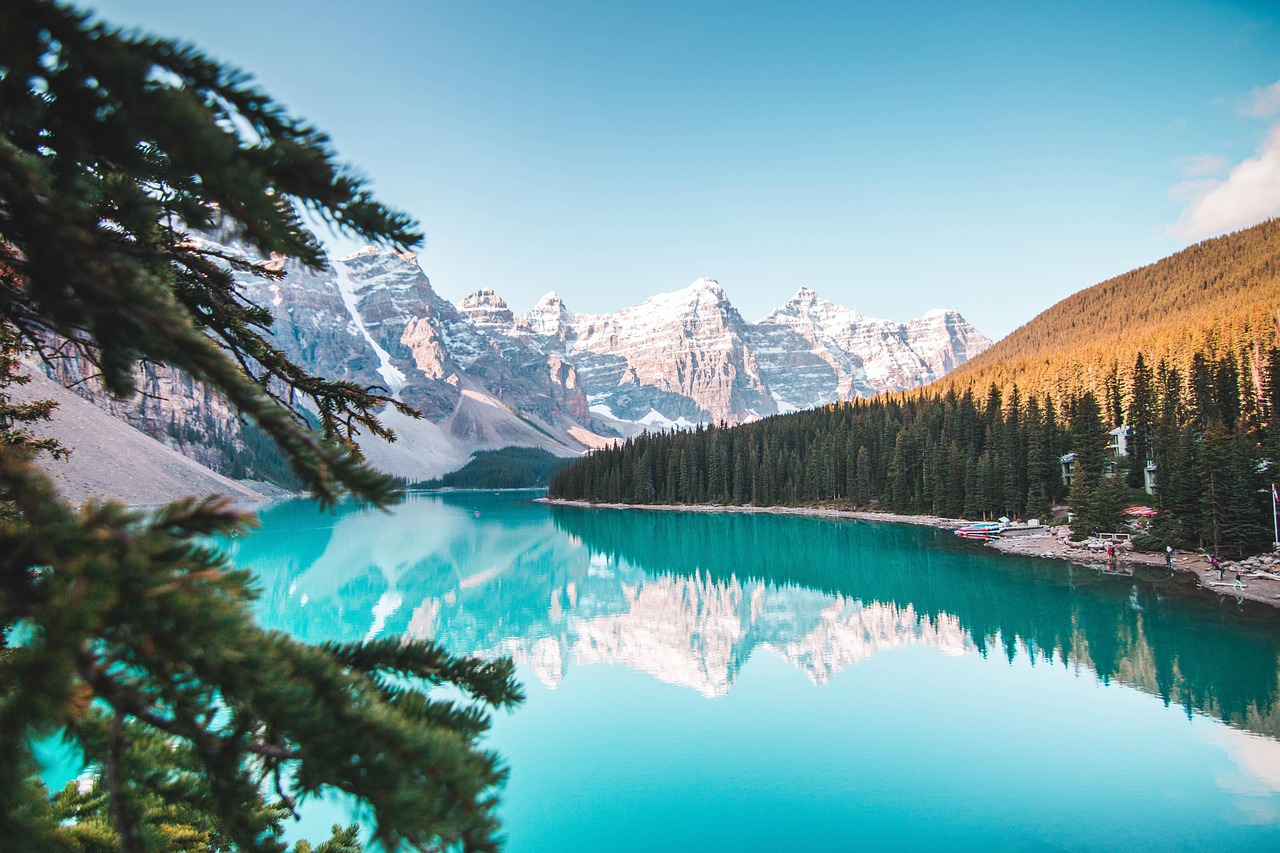 Immersion dans les grands espaces canadiens Paysage hivernal au Canada avec montagnes, sapins enneigés et rivière gelée – destination proposée par Mundo Studio