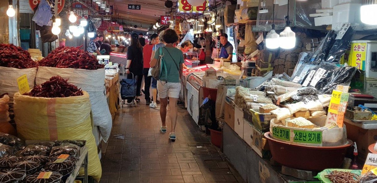 Scène de marché local en Asie : couleurs, produits frais et ambiance vivante Étals de fruits et légumes dans un marché asiatique animé, avec des vendeurs locaux, paniers traditionnels et produits frais colorés
