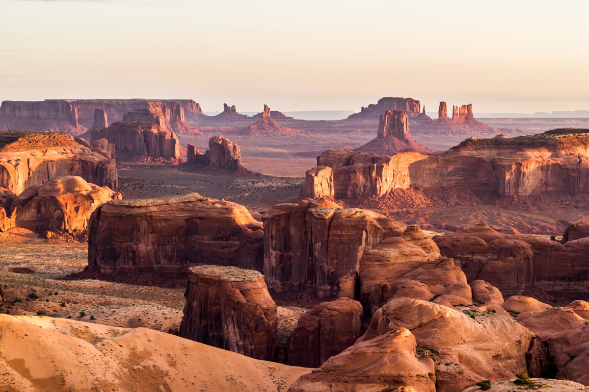 Panorama de Monument Valley – Immersion dans les terres sacrées de l’Ouest américain Vue panoramique de Monument Valley au lever du soleil, formations rocheuses emblématiques du désert de l’Ouest américain, entre traditions navajo et paysages mythiques.
